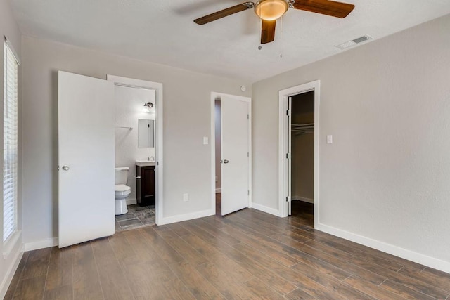 5808 Cherry Park, Austin, TX 78745 - unfurnished bedroom featuring wood finished floors, a walk in closet, ensuite bath, and a closet
