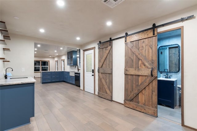 318 W Hackberry St, Fredericksburg, TX 78624 - kitchen featuring a barn door, open shelves, blue cabinets, recessed lighting, and light wood-style flooring