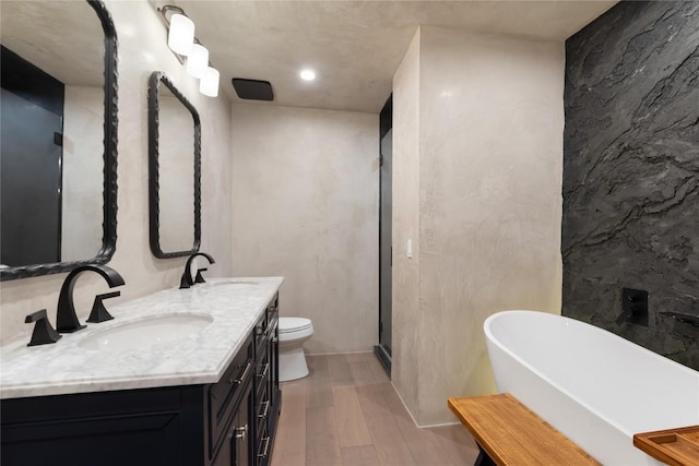 318 W Hackberry St, Fredericksburg, TX 78624 - full bathroom with wood finished floors, double vanity, a freestanding tub, and recessed lighting