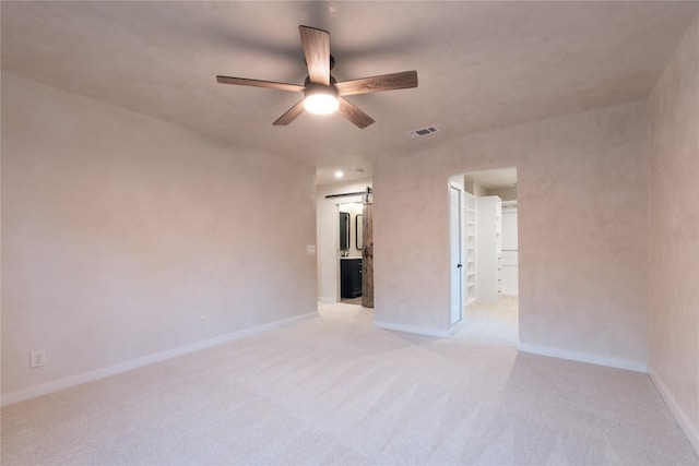 318 W Hackberry St, Fredericksburg, TX 78624 - spare room featuring a ceiling fan, light carpet, and a barn door