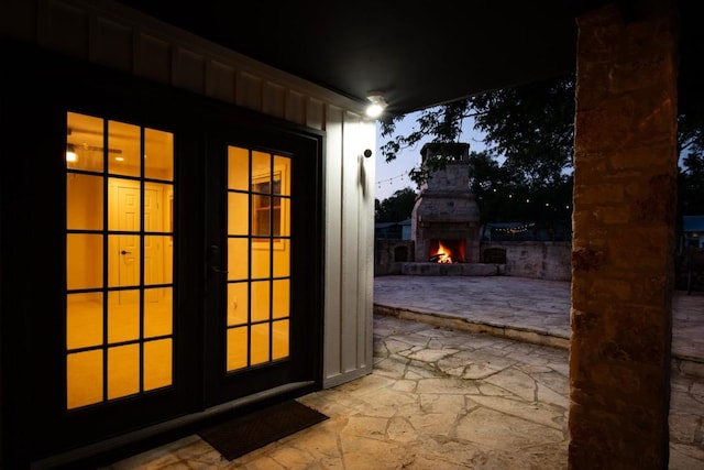318 W Hackberry St, Fredericksburg, TX 78624 - doorway featuring stone floors, french doors, and a warm lit fireplace