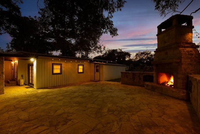 318 W Hackberry St, Fredericksburg, TX 78624 - back of property at dusk with a patio and a warm lit fireplace