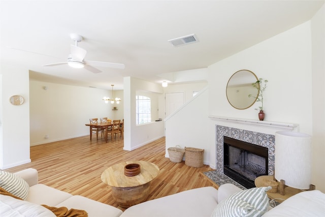 16704 Shipshaw River Cv, Leander, TX 78641 - living room featuring wood finished floors, a fireplace, a chandelier, and a ceiling fan