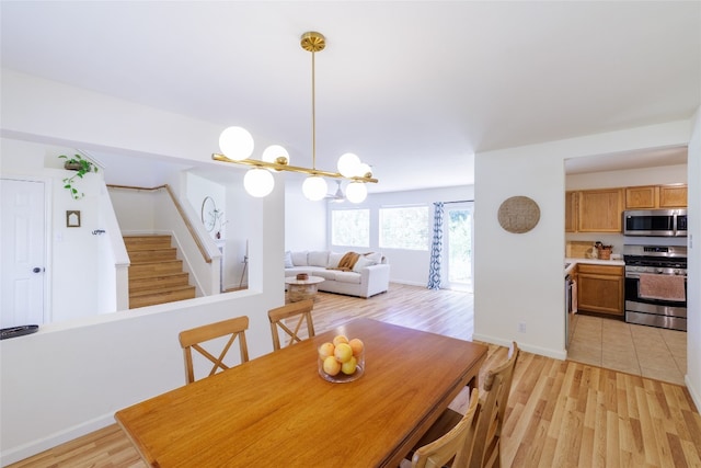 16704 Shipshaw River Cv, Leander, TX 78641 - dining area featuring stairs, light wood finished floors, and a chandelier