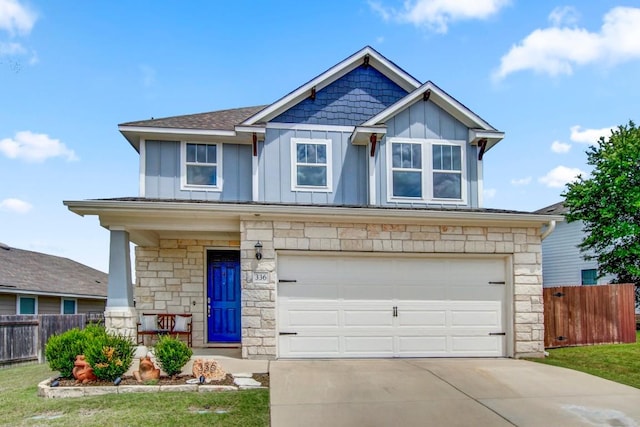 336 Gaida Loop, Georgetown, TX 78628 - view of front facade with stone siding, board and batten siding, concrete driveway, and a garage