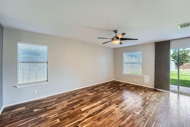14418 Cummins Way, Manor, TX 78653 - unfurnished room featuring dark wood-style floors, plenty of natural light, and ceiling fan