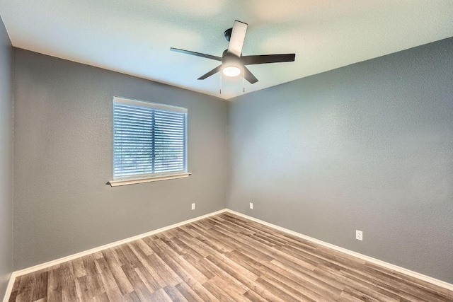 14418 Cummins Way, Manor, TX 78653 - spare room featuring wood finished floors, a ceiling fan, and a textured wall