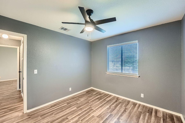 14418 Cummins Way, Manor, TX 78653 - spare room featuring wood finished floors, a ceiling fan, and a textured wall