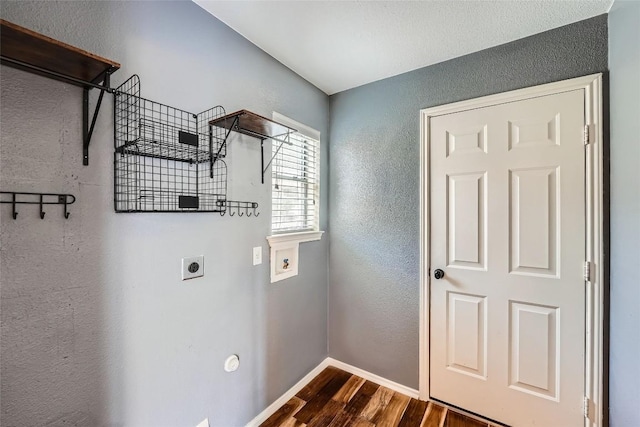 14418 Cummins Way, Manor, TX 78653 - washroom featuring electric dryer hookup, a textured wall, dark wood-style flooring, and hookup for a washing machine