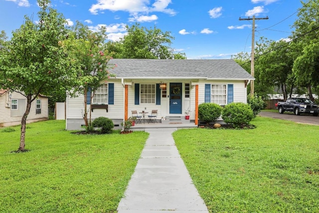 707 Wilson St, Taylor, TX 76574 - view of front of house with a porch, a front yard, and a shingled roof