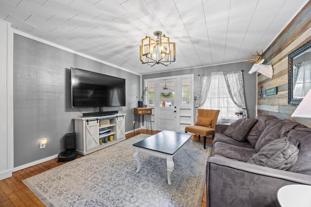 707 Wilson St, Taylor, TX 76574 - living room featuring wood-type flooring, ornamental molding, and a chandelier