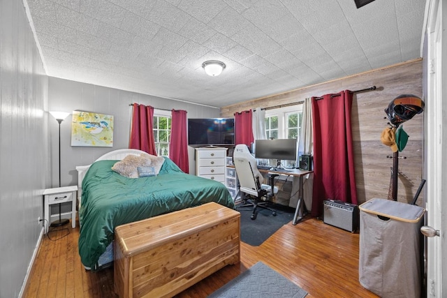 707 Wilson St, Taylor, TX 76574 - bedroom with an office area, hardwood / wood-style flooring, and wooden walls