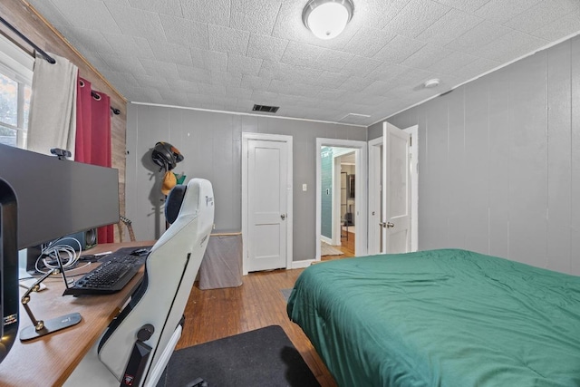 707 Wilson St, Taylor, TX 76574 - bedroom with hardwood / wood-style floors and an office area