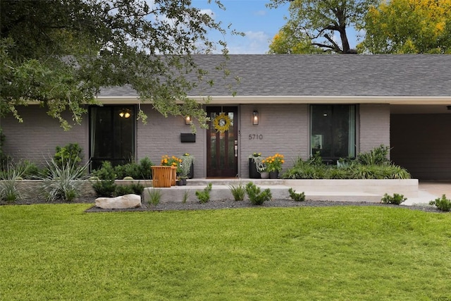 5710 Marilyn Dr, Austin, TX 78757 - view of front facade with brick siding, a front yard, and roof with shingles