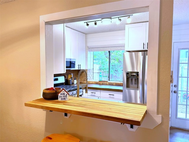 1411 Gracy Farms Ln Unit 130, Austin, TX 78758 - kitchen with stainless steel appliances, wood counters, white cabinets, and healthy amount of natural light