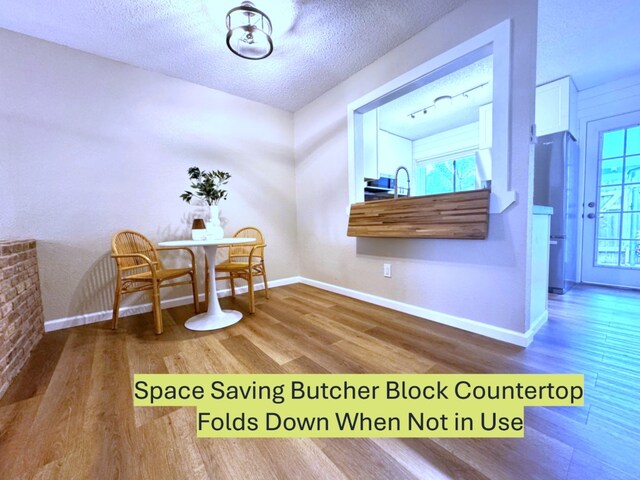 1411 Gracy Farms Ln Unit 130, Austin, TX 78758 - dining space with wood finished floors and a textured ceiling