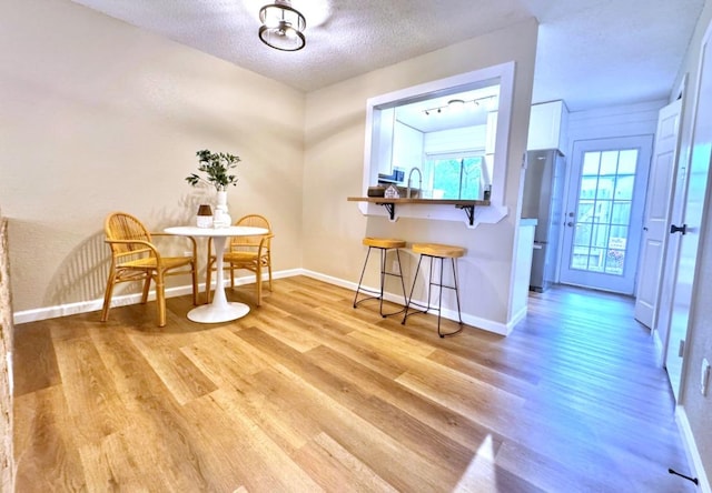 1411 Gracy Farms Ln Unit 130, Austin, TX 78758 - dining area featuring light wood-style flooring, healthy amount of natural light, and a textured ceiling