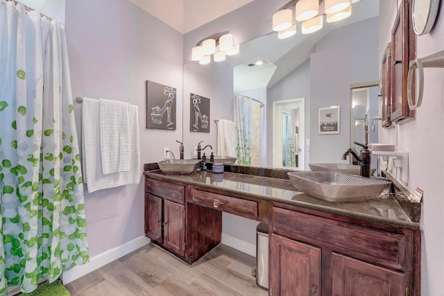 402 Oakcrest Dr, Cedar Park, TX 78613 - bathroom featuring wood finished floors, double vanity, vaulted ceiling, and curtained shower