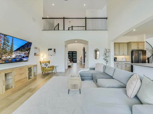 11901 Pier Ct, Austin, TX 78737 - living room with a high ceiling, arched walkways, light wood-style floors, and stairs