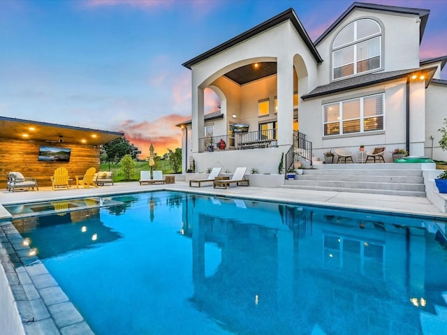 11901 Pier Ct, Austin, TX 78737 - rear view of house with stucco siding, a pool with connected hot tub, and a patio area
