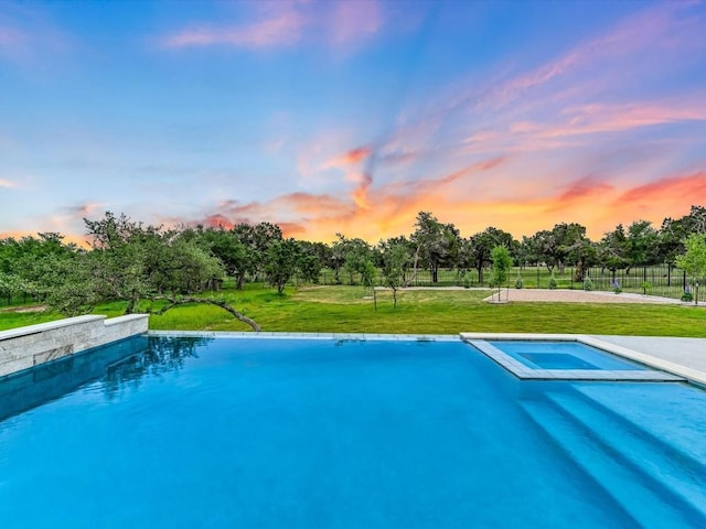 11901 Pier Ct, Austin, TX 78737 - pool at dusk featuring a yard, a pool with connected hot tub, and view of scattered trees