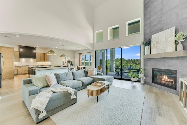 11901 Pier Ct, Austin, TX 78737 - living room with a high ceiling, light wood-style flooring, a tile fireplace, and recessed lighting