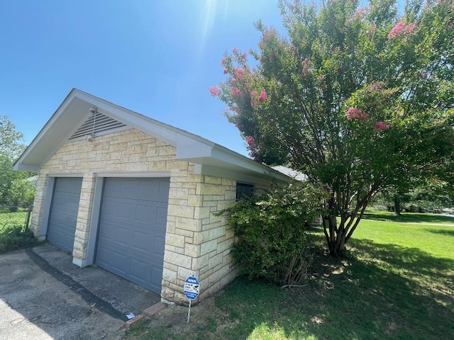 601 S Arnold St S, Lampasas, TX 76550 - view of side of property featuring stone siding, a garage, and a lawn