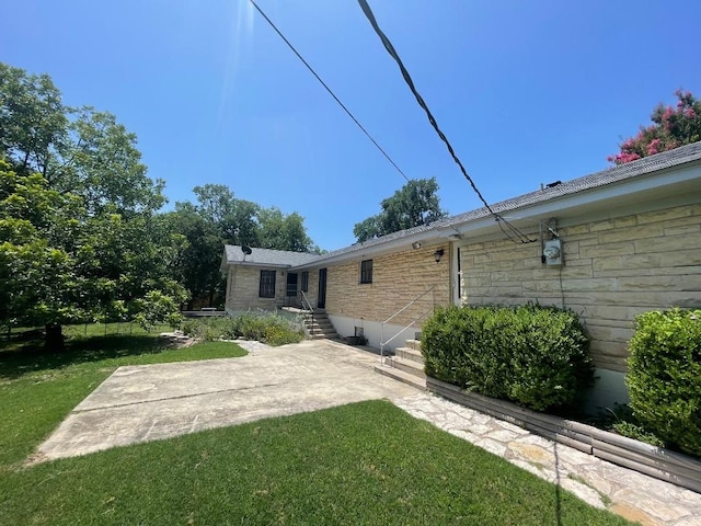 601 S Arnold St S, Lampasas, TX 76550 - rear view of house with stone siding, a yard, and a patio