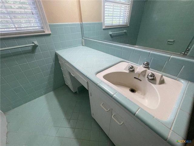 601 S Arnold St S, Lampasas, TX 76550 - bathroom with vanity, tile walls, healthy amount of natural light, tile patterned floors, and wainscoting