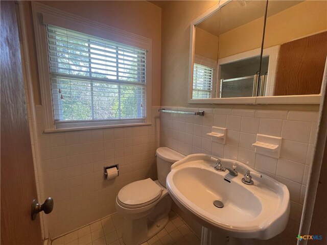 601 S Arnold St S, Lampasas, TX 76550 - bathroom featuring tile patterned floors, tile walls, a shower, and wainscoting