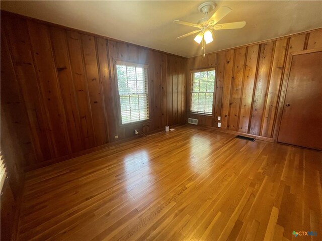 601 S Arnold St S, Lampasas, TX 76550 - unfurnished room with light wood finished floors, a ceiling fan, and wooden walls