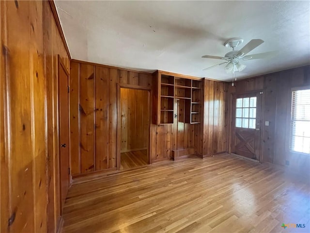 601 S Arnold St S, Lampasas, TX 76550 - unfurnished living room with wooden walls, light wood-style flooring, and ceiling fan