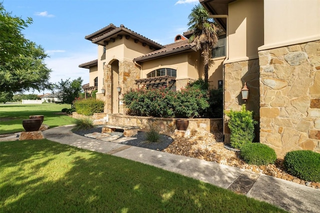 307 Goodnight Dr, Georgetown, TX 78628 - view of front facade featuring stone siding, stucco siding, a front lawn, and a tiled roof