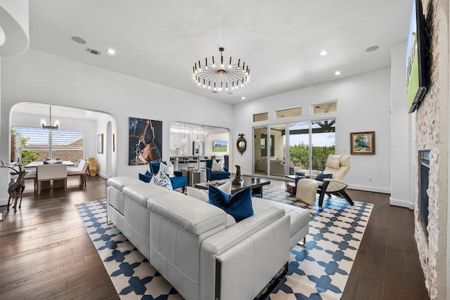 203 Black Stone Cv, Driftwood, TX 78619 - living room with a chandelier, arched walkways, recessed lighting, hardwood / wood-style flooring, and a stone fireplace