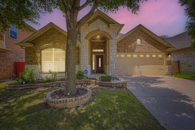 9728 Alex Ln, Austin, TX 78748 - french country inspired facade with stone siding, a garage, driveway, brick siding, and a front lawn
