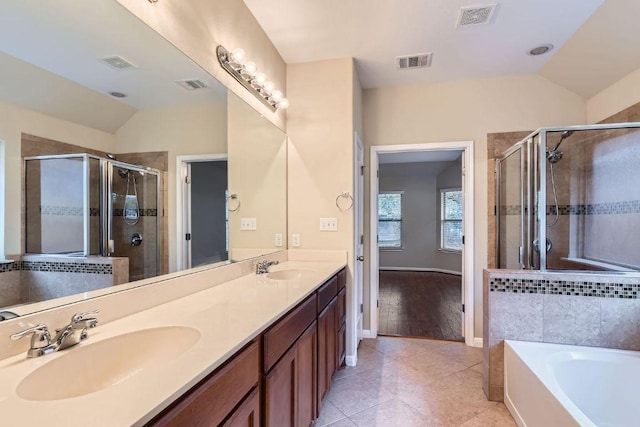 9728 Alex Ln, Austin, TX 78748 - full bath featuring vaulted ceiling, a bath, a shower stall, double vanity, and tile patterned flooring