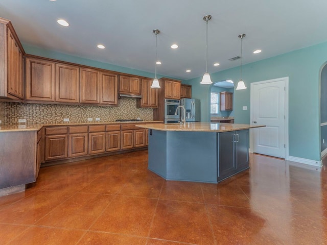 100 N Meadowlark St, Lakeway, TX 78734 - kitchen with arched walkways, brown cabinetry, backsplash, appliances with stainless steel finishes, and recessed lighting