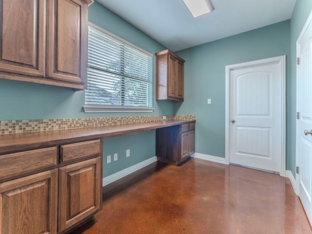 100 N Meadowlark St, Lakeway, TX 78734 - kitchen featuring concrete flooring, built in study area, and brown cabinets
