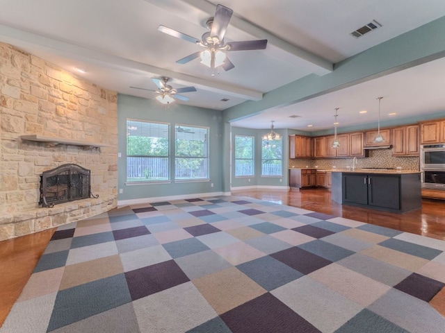 100 N Meadowlark St, Lakeway, TX 78734 - unfurnished living room featuring ceiling fan, a stone fireplace, beamed ceiling, and recessed lighting
