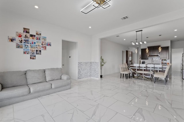 1332 Al Fresco Cv, Leander, TX 78641 - living room with light marble finish flooring, recessed lighting, and a chandelier