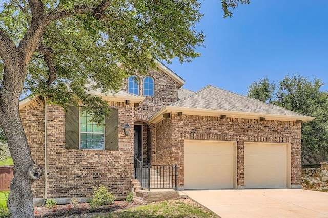 851 Catalina Ln, Austin, TX 78737 - view of front facade featuring an attached garage, concrete driveway, brick siding, and a shingled roof