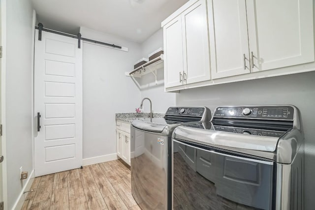 213 Woodland Hills Dr, Georgetown, TX 78633 - laundry area with cabinet space, washer and dryer, light wood-type flooring, and a barn door