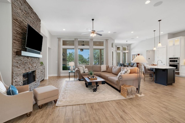 213 Woodland Hills Dr, Georgetown, TX 78633 - living area featuring a stone fireplace, a ceiling fan, light wood finished floors, and recessed lighting