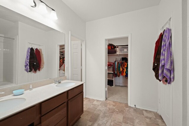 538 Thunder Valley Trl, Georgetown, TX 78626 - bathroom featuring a walk in closet, double vanity, and a shower