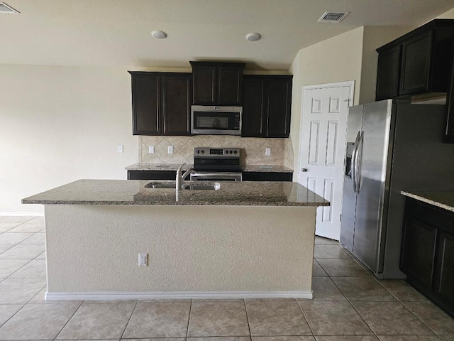 9405 Glynhill Ct, Killeen, TX 76542 - kitchen with appliances with stainless steel finishes, dark stone countertops, backsplash, and a kitchen island with sink