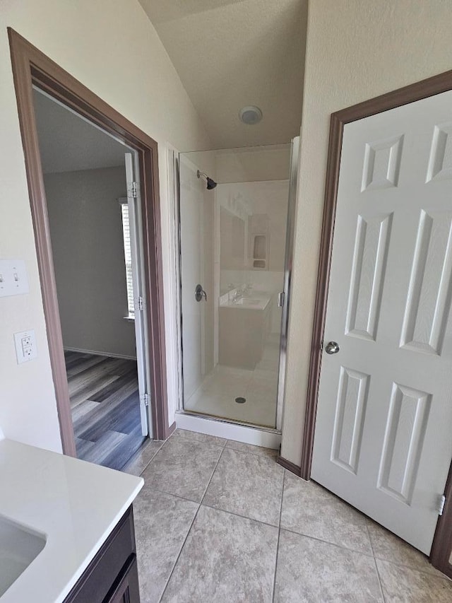 9405 Glynhill Ct, Killeen, TX 76542 - full bathroom featuring a shower stall, vanity, vaulted ceiling, and tile patterned flooring
