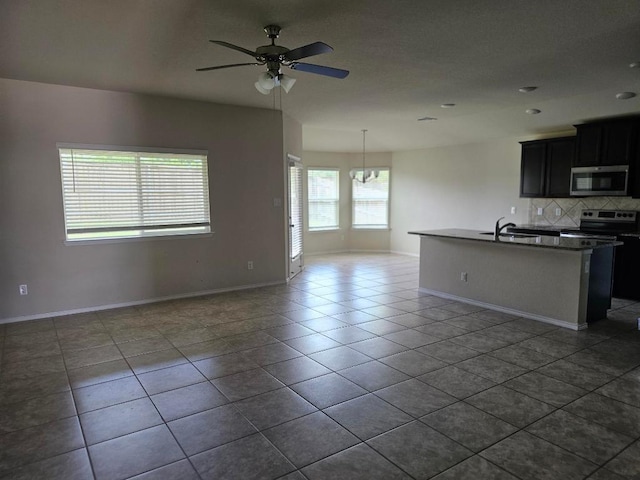 9405 Glynhill Ct, Killeen, TX 76542 - kitchen featuring appliances with stainless steel finishes, open floor plan, tasteful backsplash, ceiling fan, and dark tile patterned flooring