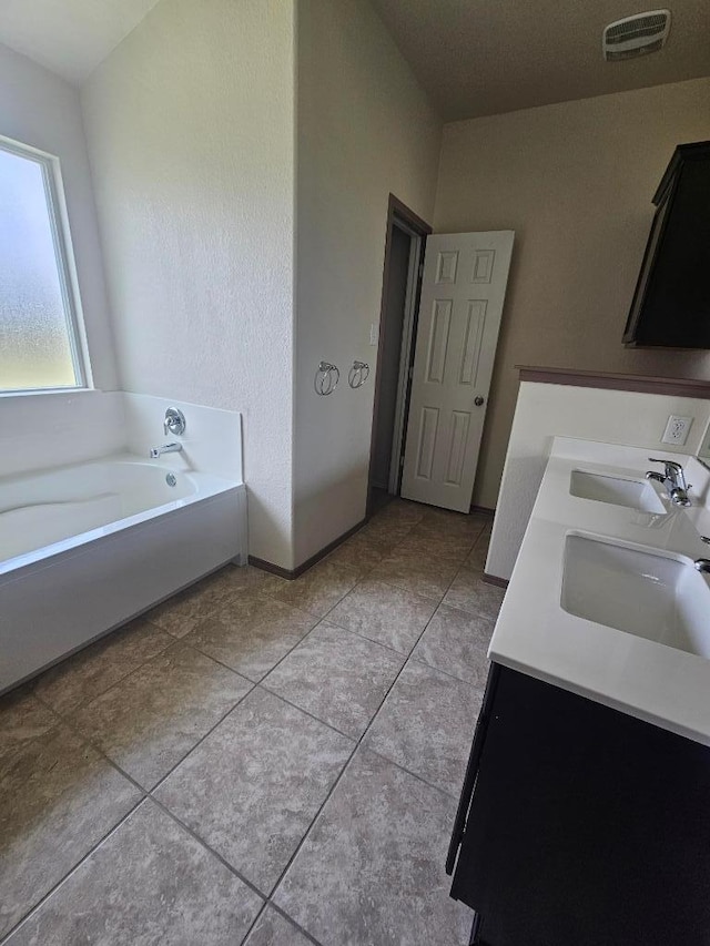 9405 Glynhill Ct, Killeen, TX 76542 - full bath with double vanity, tile patterned floors, and a garden tub
