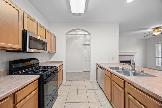 716 Bent Wood Pl, Round Rock, TX 78665 - kitchen with stainless steel appliances, a tiled fireplace, light countertops, and light tile patterned flooring