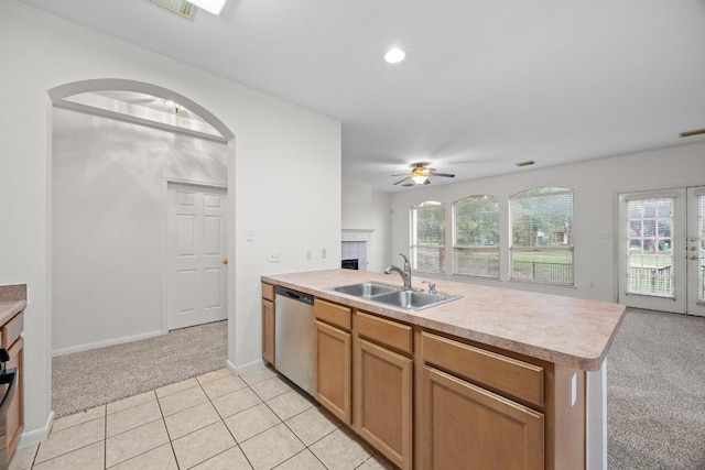 716 Bent Wood Pl, Round Rock, TX 78665 - kitchen featuring dishwasher, light colored carpet, a peninsula, a tiled fireplace, and light countertops